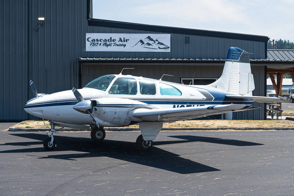 Beechcraft Travel Air BE95 N95WT parked in front of the Cascade Air hangar at KKLS.